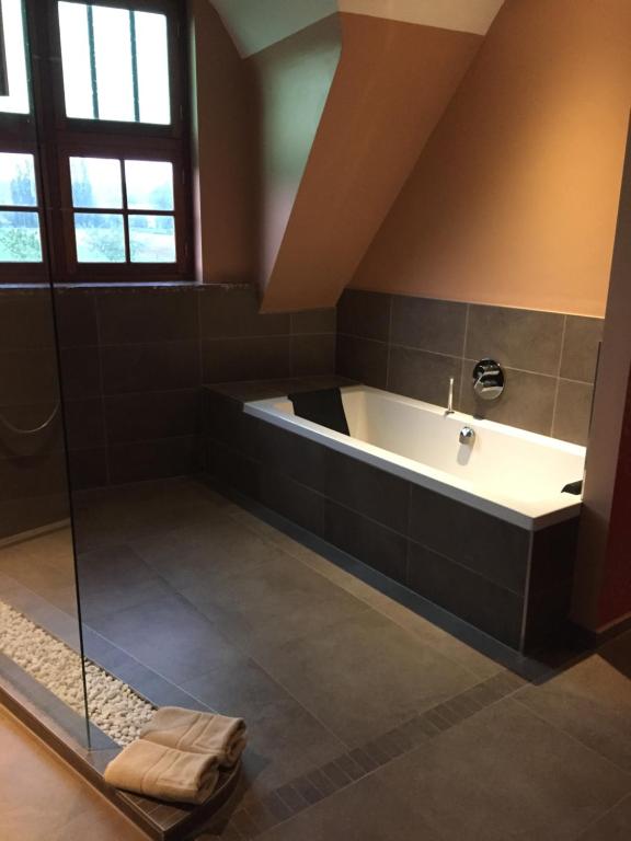 a large bathroom with a tub and a shower at Ferme Delgueule in Tournai