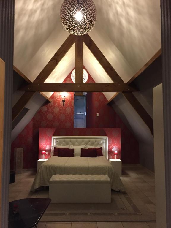 a bedroom with a bed and a ceiling with beams at Ferme Delgueule in Tournai