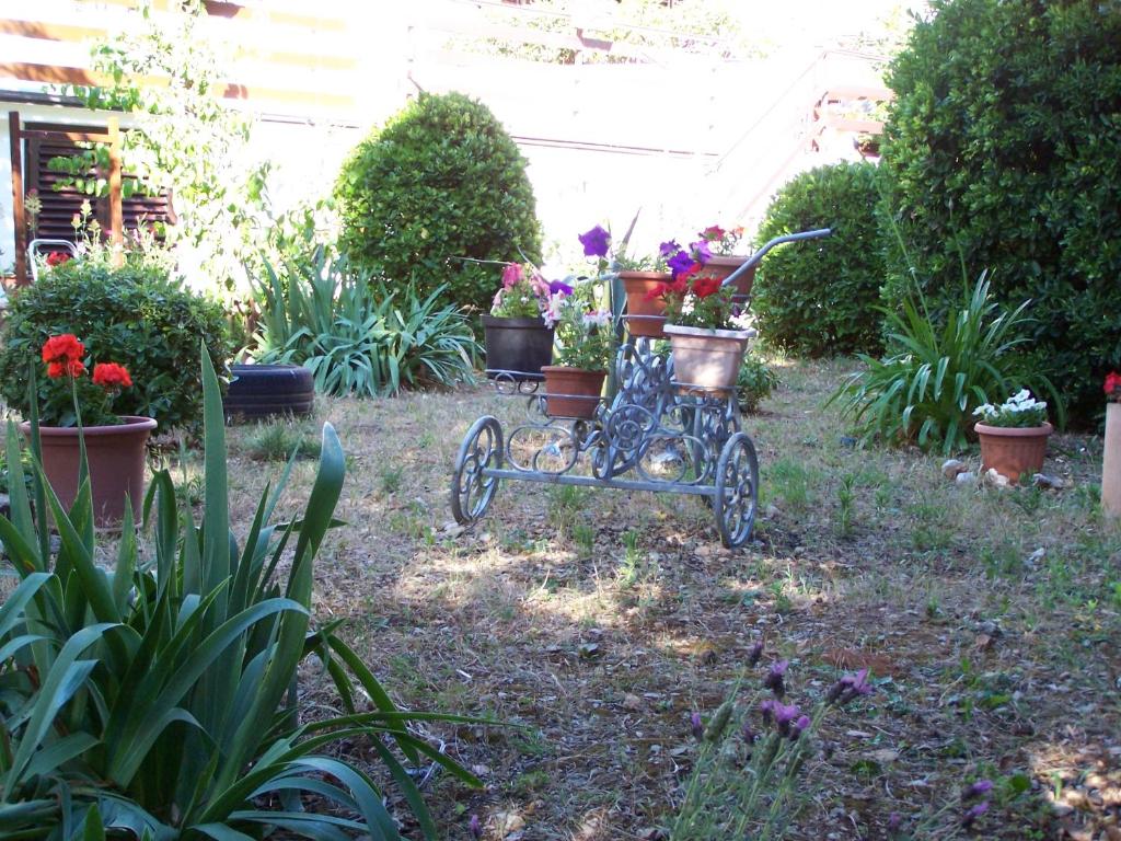 a garden with a cart with flowers and plants at Apartments Šestan in Novalja