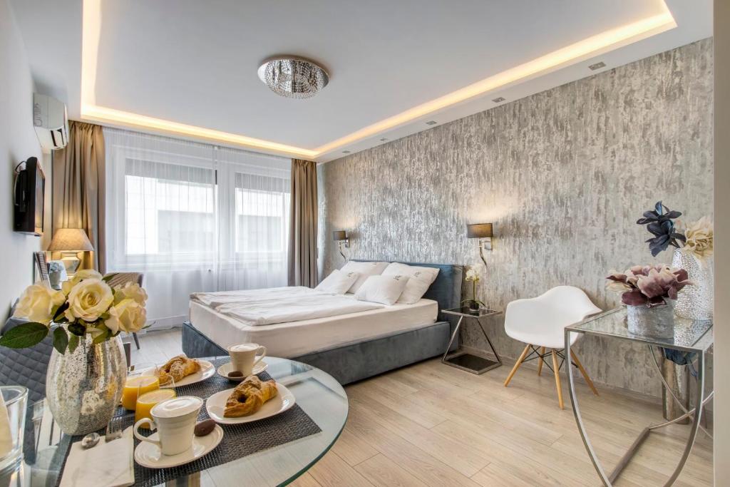 ブダペストにあるDanube Corso Boutique Apartmentのベッドとテーブルが備わるホテルルームです。