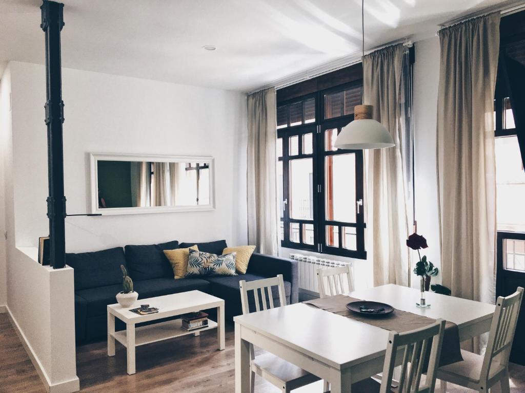 sala de estar con sofá azul y mesa en Apartamentos Pozo Amarillo en Salamanca