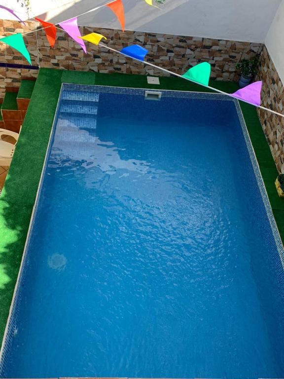 a large blue swimming pool with colorful flags above it at Casa al-andalus in Granada