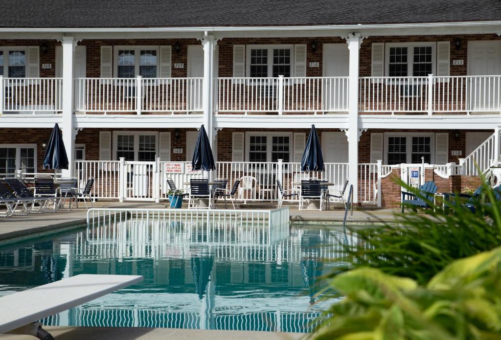 a swimming pool in front of a hotel with chairs at Saratoga Resort in Wildwood Crest