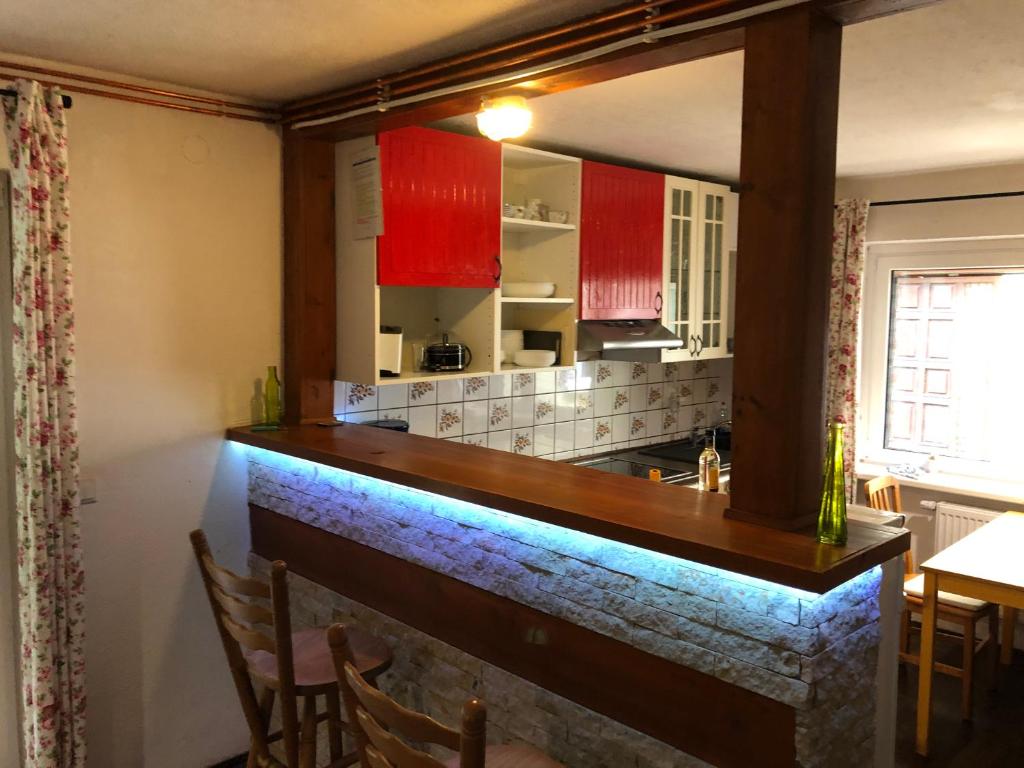 cocina con armarios rojos y encimera de piedra en Ferienhaus-Elisabeth Bungalow-Tom Bungalow-Peter, en Reinhardtsdorf