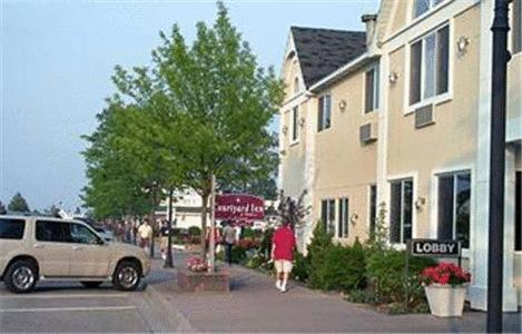 una mujer caminando por una calle al lado de un edificio en Court Plaza Inn & Suites of Mackinaw, en Mackinaw City