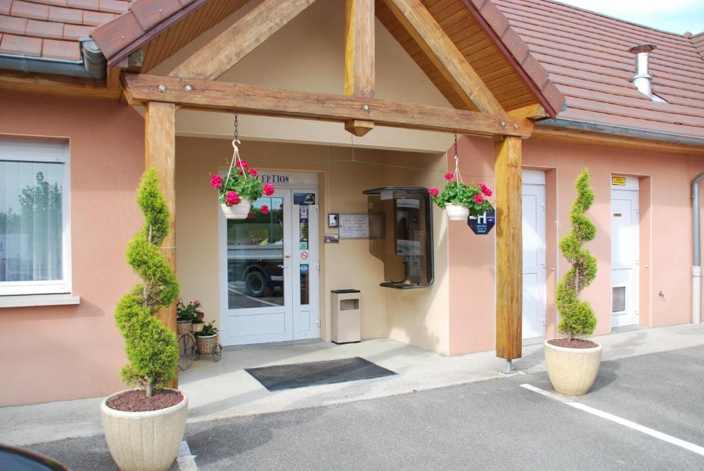 un edificio con macetas delante de una puerta en Europe Hotel, en Beaurepaire-en-Bresse