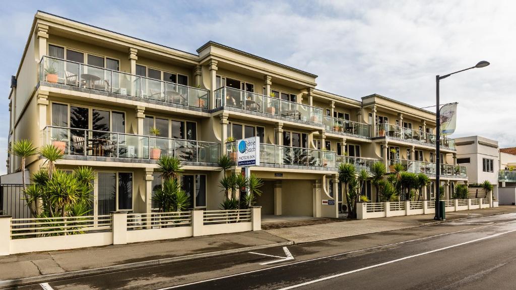 an apartment building with balconies on a street at Pebble Beach Motor Inn in Napier