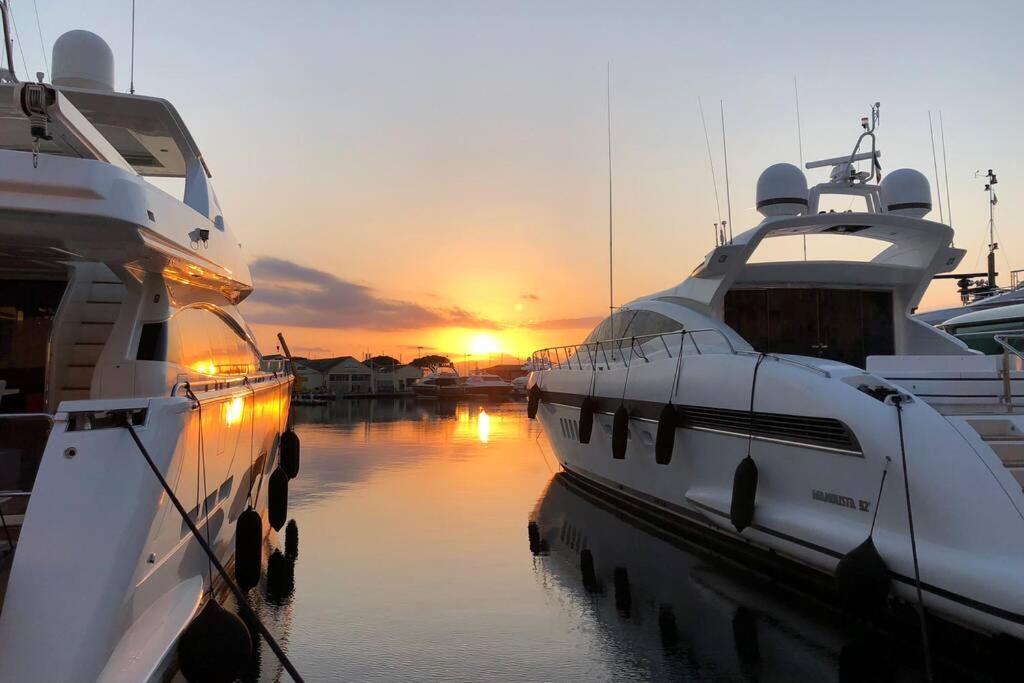 deux bateaux amarrés dans l'eau avec le coucher du soleil en arrière-plan dans l'établissement Charming apartment in Port Grimaud, à Grimaud