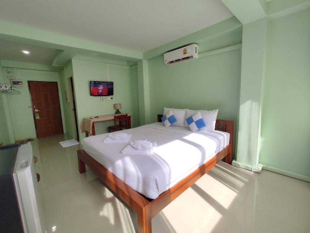 a bedroom with a large bed in a room at Ban Mae Boonthong in Lampang