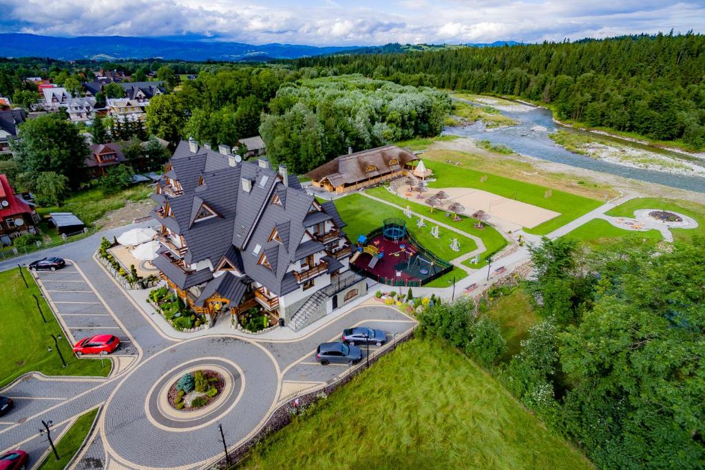 an aerial view of a large house with a river at Pensjonat Burkaty in Białka Tatrzańska