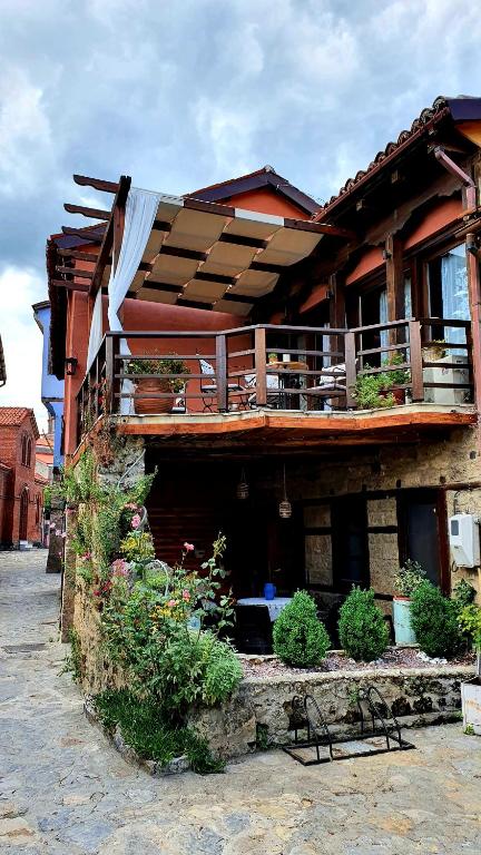 a building with a balcony with plants on it at Varosi Guesthouse in Edessa