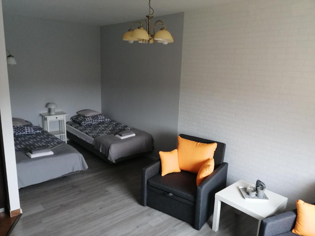 弗次瓦夫的住宿－Witkowska-nocleg，一间卧室配有两张床、一把椅子和一张沙发