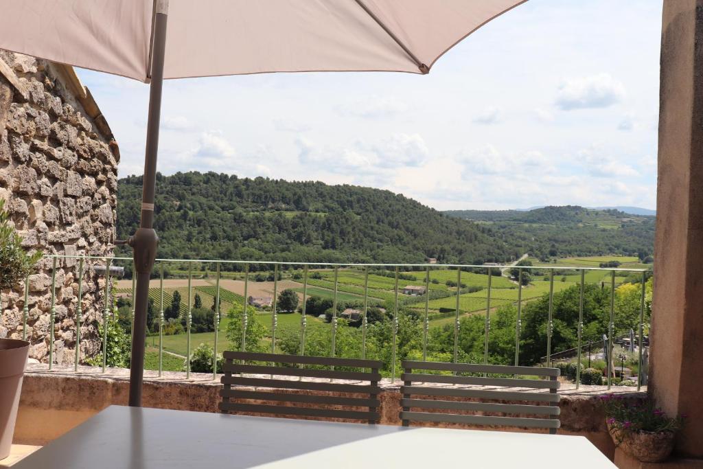 a view from the balcony of a house with an umbrella at L'Ensoleillée in Ménerbes