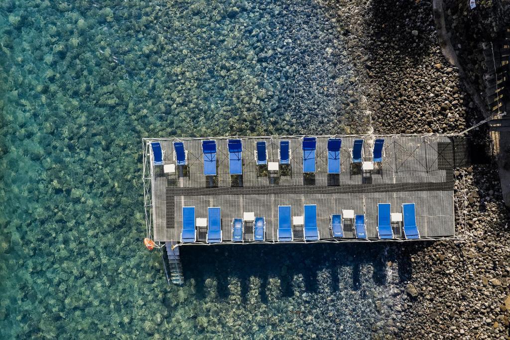 an aerial view of a dock with chairs in the water at Hotel Continental Mare in Ischia