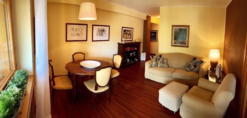 a living room with a table and a couch at Elegante trilocale con garage, terrazzo e vista montagne in Bardonecchia