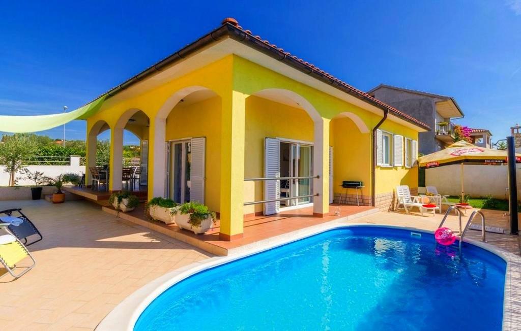 a yellow house with a swimming pool in front of it at Villa Sweet Home in Vodnjan