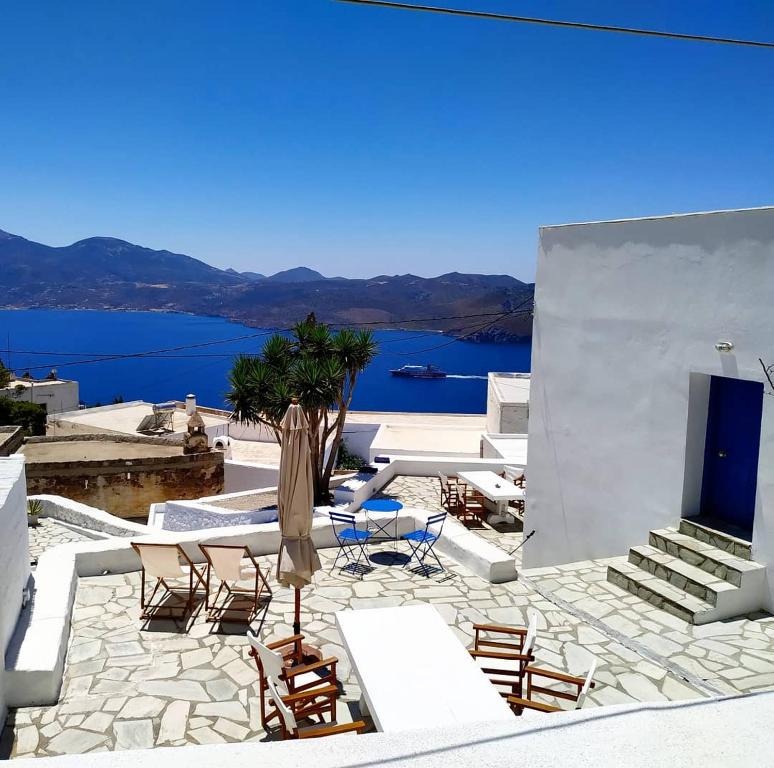 un patio con sillas y una mesa y vistas al agua en Piazza Castello, en Plaka Milou