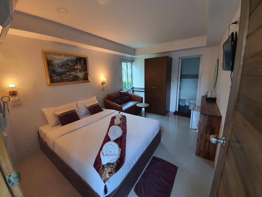 ein Schlafzimmer mit einem großen Bett und ein Wohnzimmer in der Unterkunft Chiang Mai Heritage House in Chiang Mai