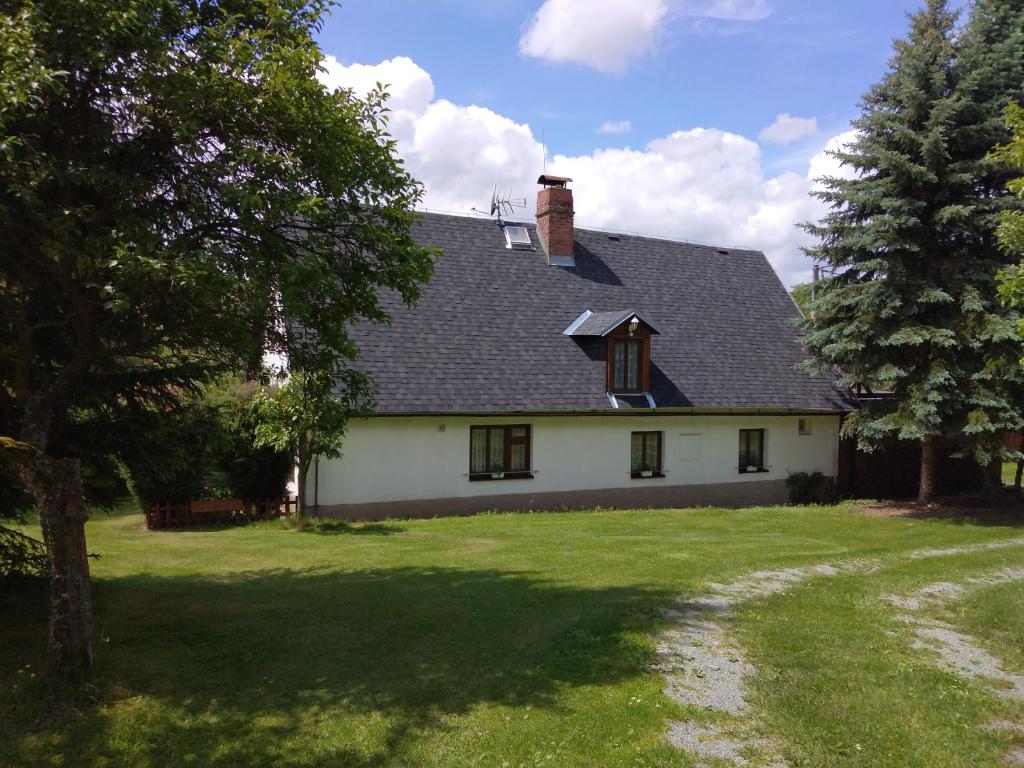 una casa blanca con techo negro y patio en Chalupa Buko, en Červený Kostelec