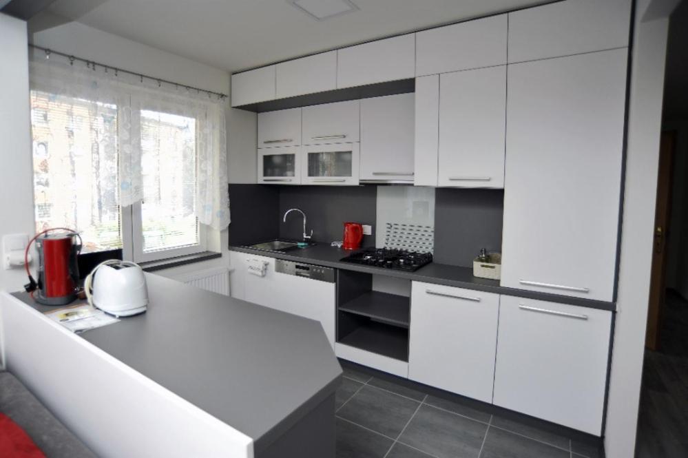 cocina con armarios blancos y encimera en Apartmán Zuzka, en Jeseník