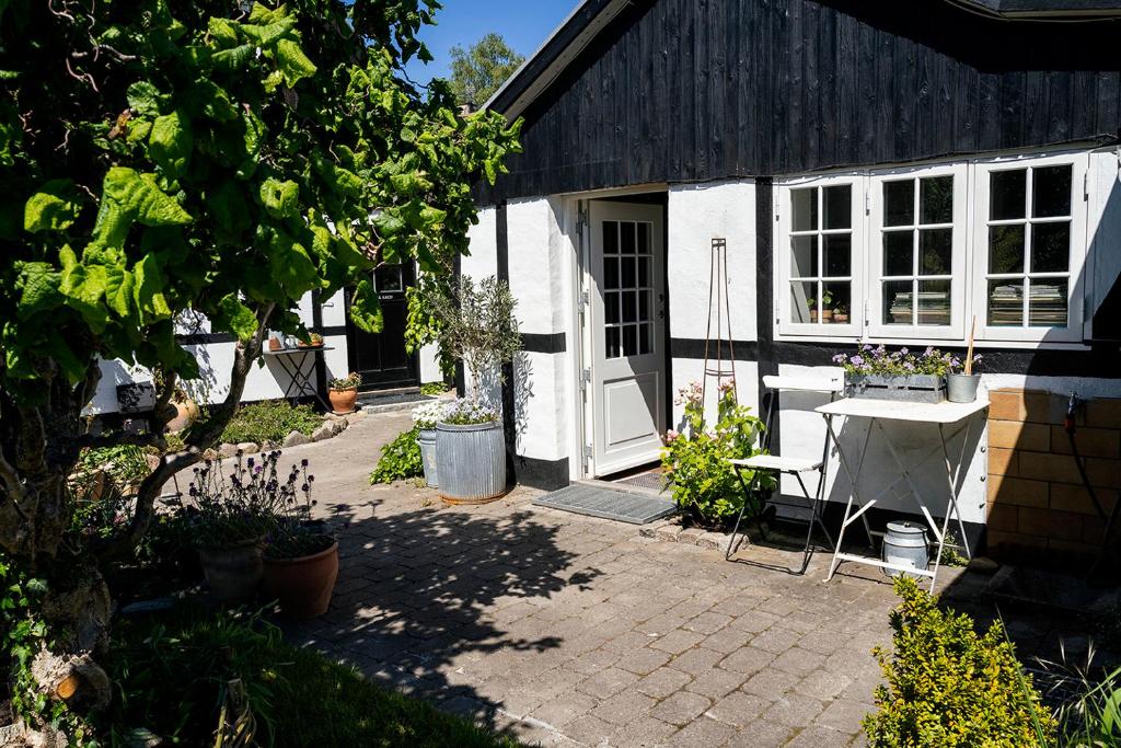 a house with a white door and a patio at Svenskebakken Bed & Breakfast in Roskilde