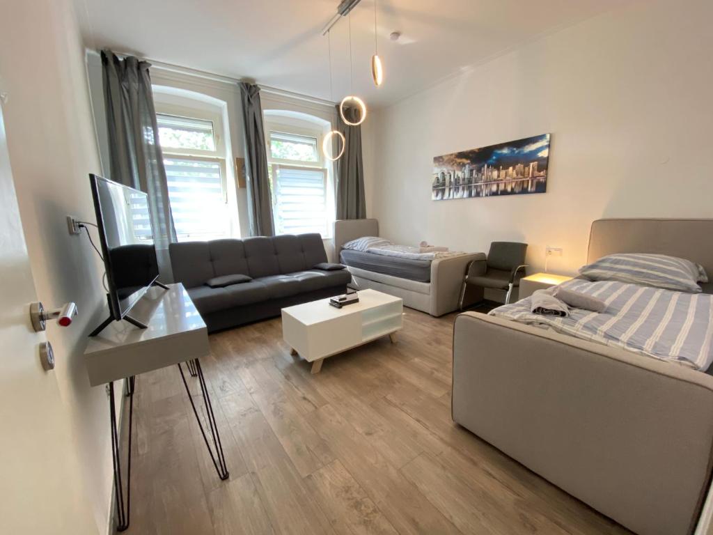 un soggiorno con divano e letto di FeWo Apartments House a Essen