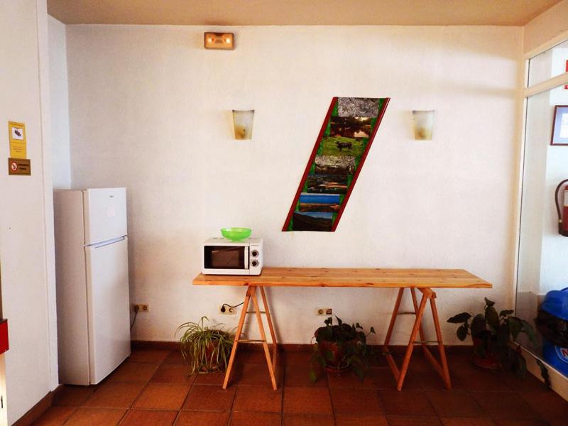 a kitchen with a refrigerator and a table at Hotel Viar in Cabezón de la Sal