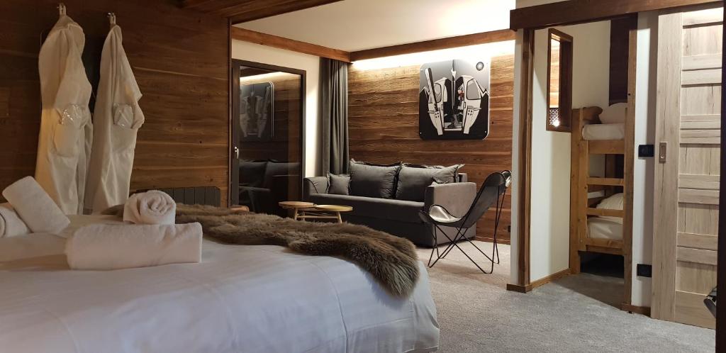 a bedroom with a bed and a living room with a couch at Chalet Marano Restaurant & Spa in Isola 2000