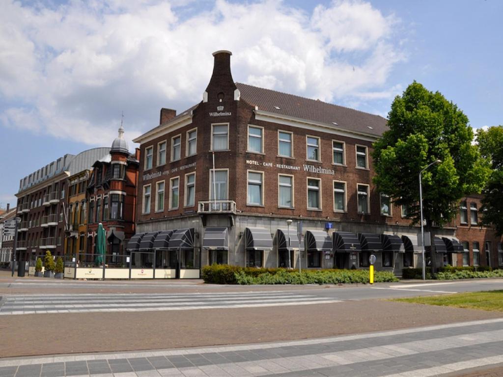 un gran edificio de ladrillo en el lateral de una calle en Hotel Wilhelmina, en Venlo