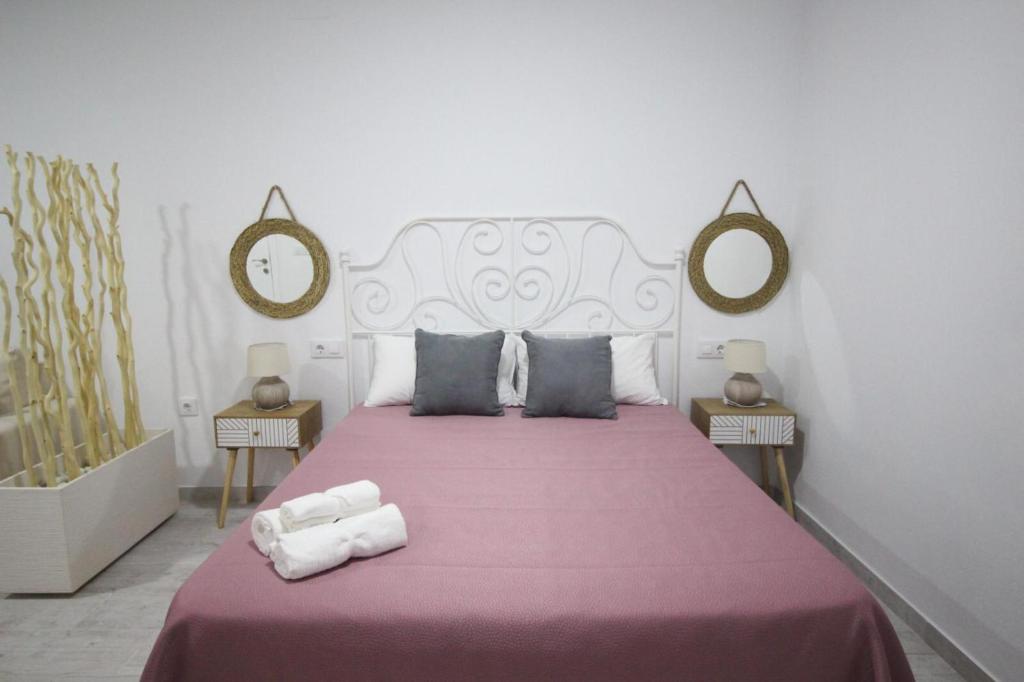 - une chambre avec un grand lit et deux miroirs dans l'établissement Estudio céntrico, à Conil de la Frontera