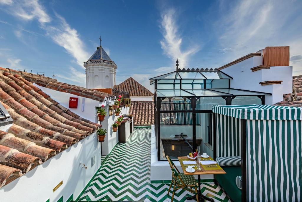 einen Balkon eines Gebäudes mit einem Uhrturm in der Unterkunft Hotel Claude Marbella in Marbella