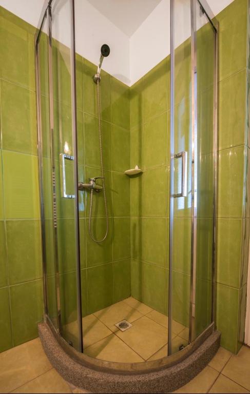 a bathroom with a shower with green walls at Vila Levent Mangalia in Mangalia