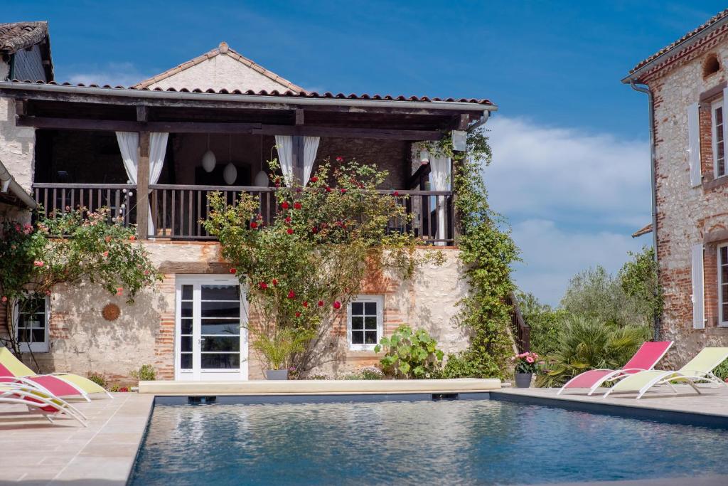 a villa with a swimming pool in front of a house at Chambres d'Hôtes Le Pignié in Lescure-dʼAlbigeois