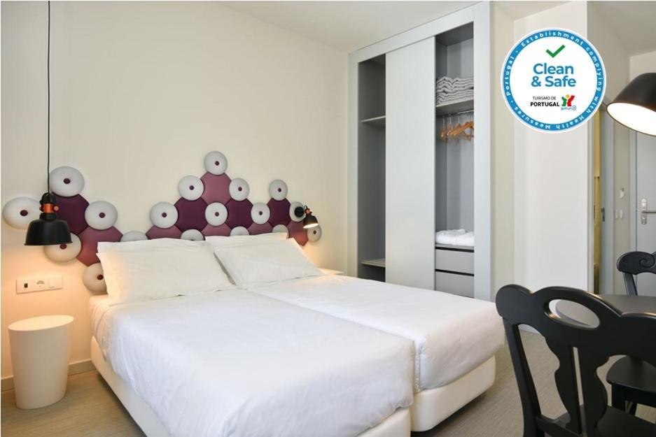 a bedroom with a white bed with a red headboard at Caçarola Dois - Alojamento local in Figueira da Foz