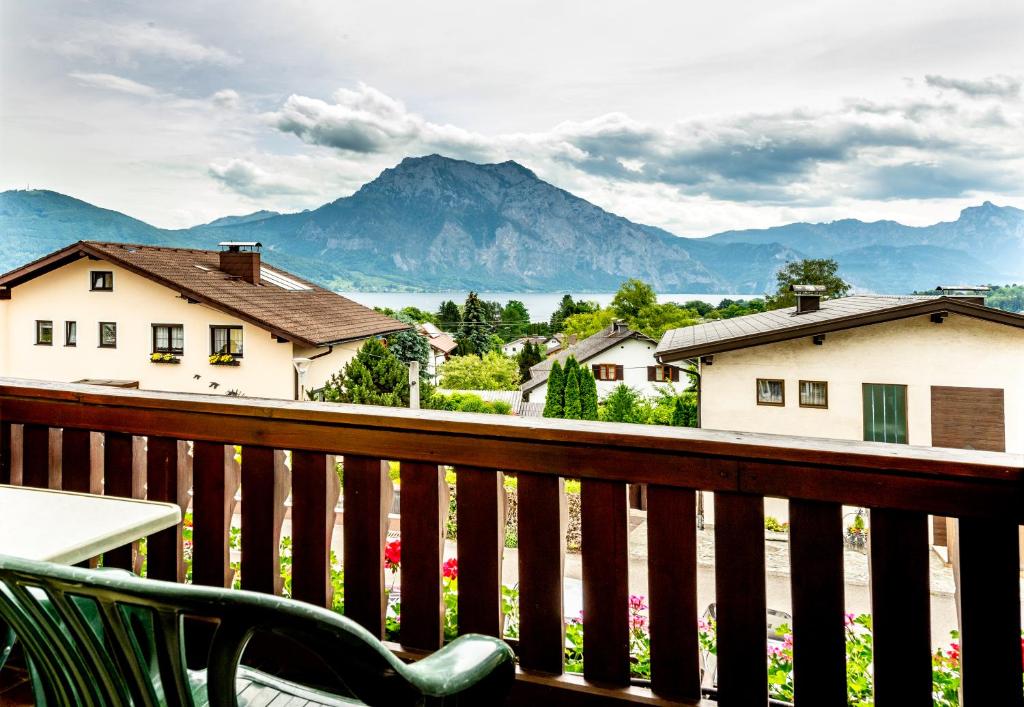 a chair on a balcony with a view of mountains at Panorama Hotel Traunstein in Altmünster