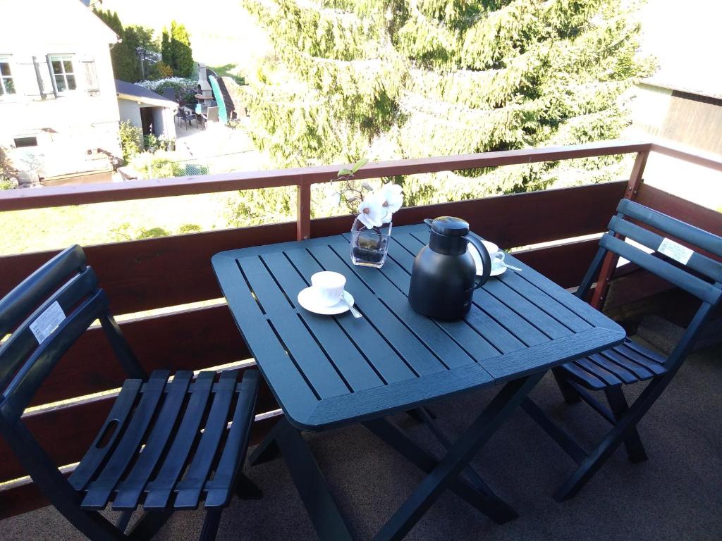a blue table and two chairs on a balcony at Ferienwohnung Rita in Freudenstadt