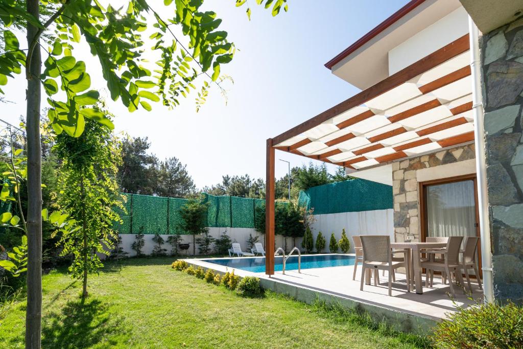 a backyard with a table and a swimming pool at Vintage Villas in Kusadası