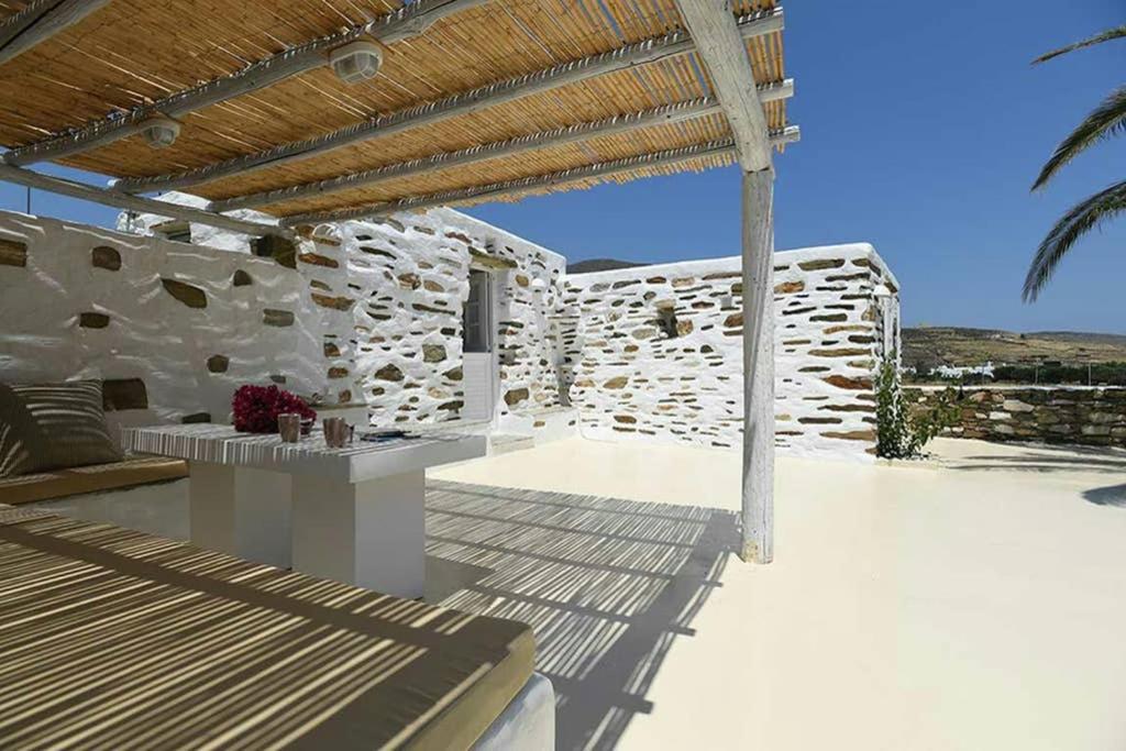 un patio con un edificio de piedra con techo de madera en Tranquil cottage, en Agios Sostis