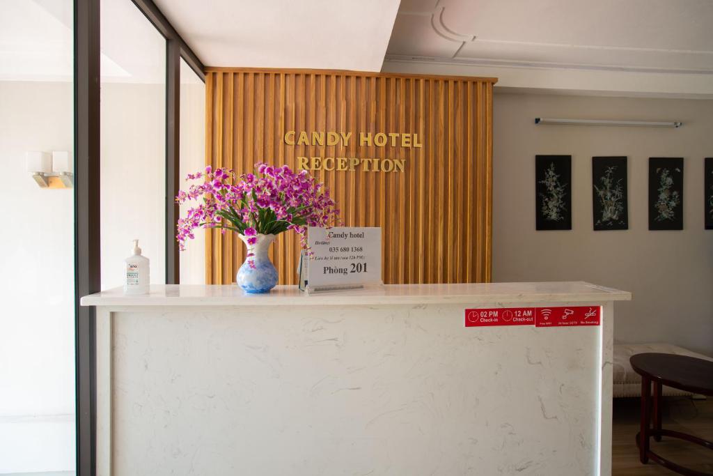 a counter with a vase of flowers on it at Candy Hotel in Ha Long