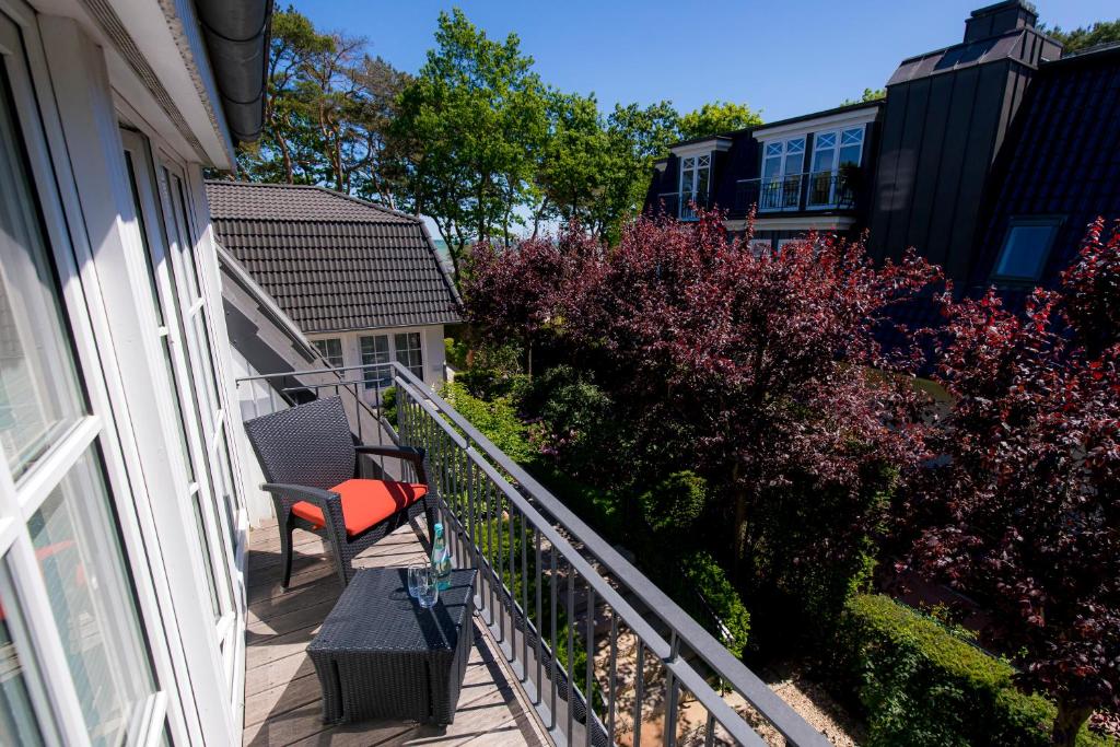 a balcony with a chair and a bench on a house at Strandhotel Fontana in Timmendorfer Strand