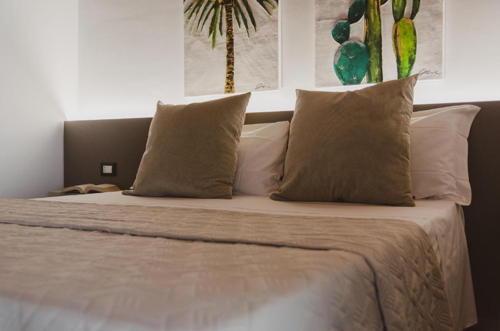 duże łóżko z białymi poduszkami w obiekcie Nonna Germina w mieście Roccalumera