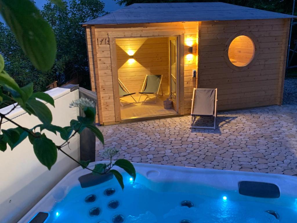 a sauna with a tub in a backyard at night at Chalet Zugspitze in Grainau