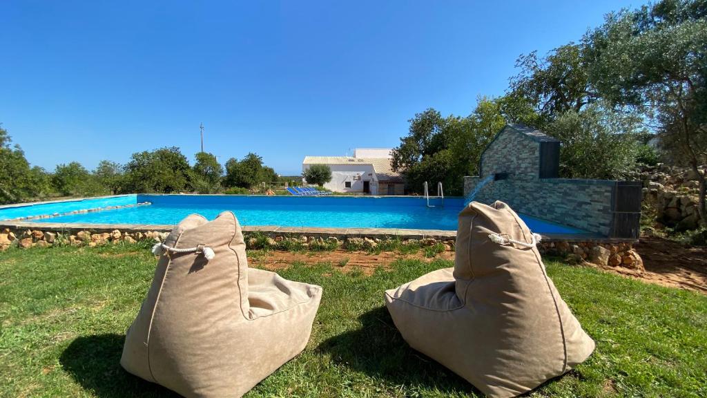 un paio di scarpe sull'erba vicino a una piscina di Gold by Check-in Portugal ad Albufeira