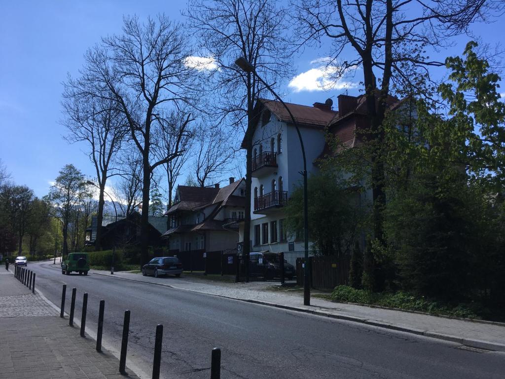 a white house on the side of a street at Blisko miło ładnie Apartament w centrum Zakopanego in Zakopane