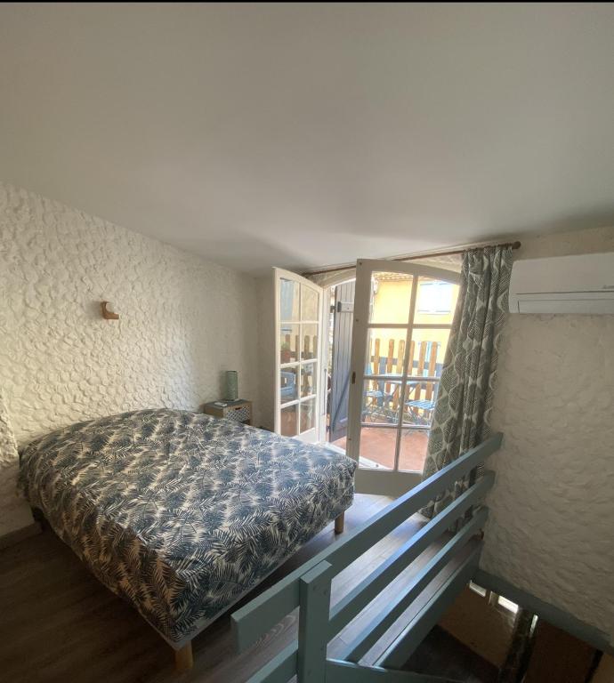 une chambre avec un lit et un balcon dans l'établissement la Palmette , NOUVEAU ! climatisée et wifi, à Lapalme