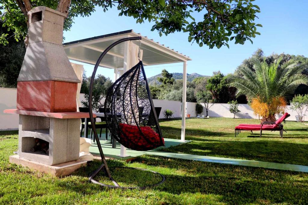 einen Garten mit einer Schaukel und einem Pavillon in der Unterkunft Adriatic Dream Apartments in Dubrovnik