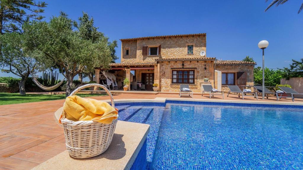 uma villa com uma cesta de vime ao lado de uma piscina em Vinyes Can Grau em Sencelles