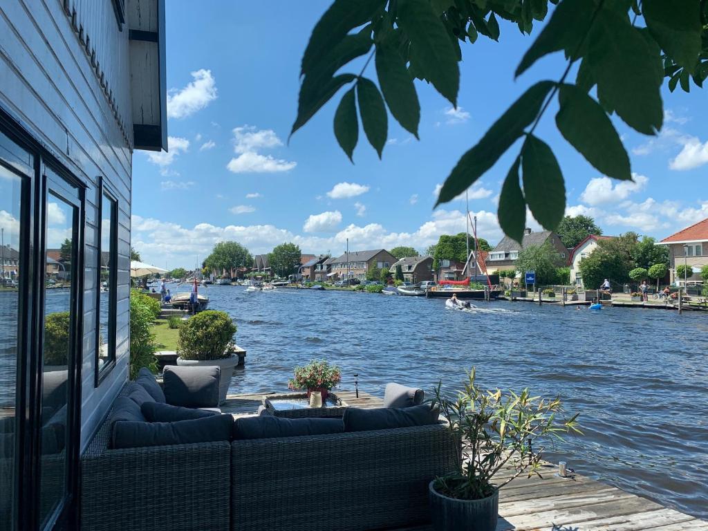 a view of a river with couches on a building at Holiday home at the water, fire place, boat and SUP rent, near Amsterdam in Aalsmeer