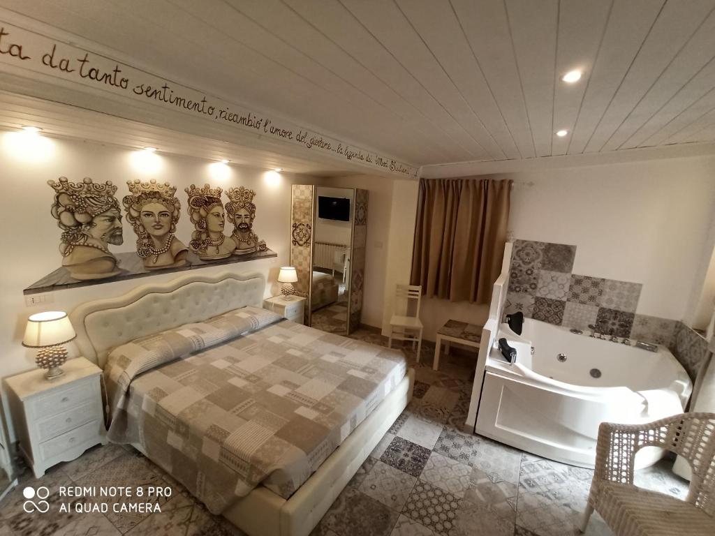 een slaapkamer met een bed en een bad in een kamer bij B&B Triskèles in Giardini Naxos