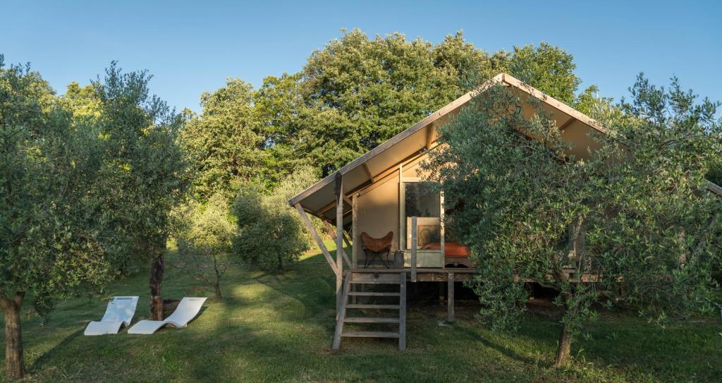 Glamping in Toscana, luxury tents in agriturismo biologico في سورانو: منزل صغير وسط بستان تفاح